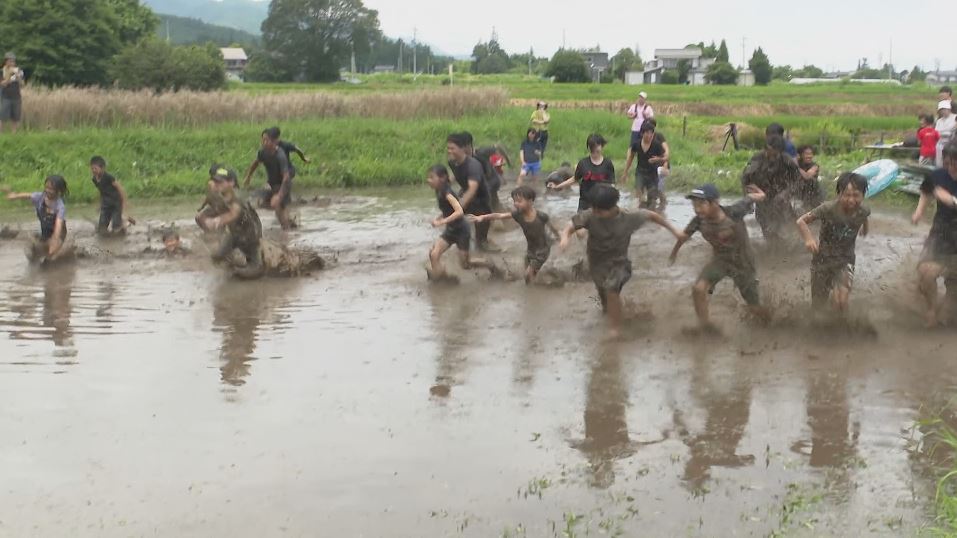 泥だらけでもお構いなし！　子どもたちが「泥リンピック」　夏の安曇野で田んぼを走る